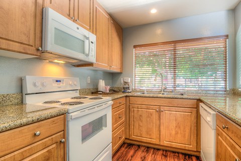 a kitchen with white appliances and wooden cabinets